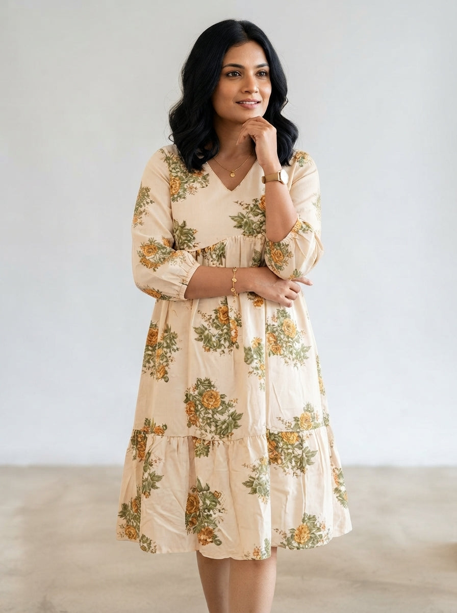 Cream and yellow floral tiered dress by AVAL featuring a flowy design and elegant floral pattern.